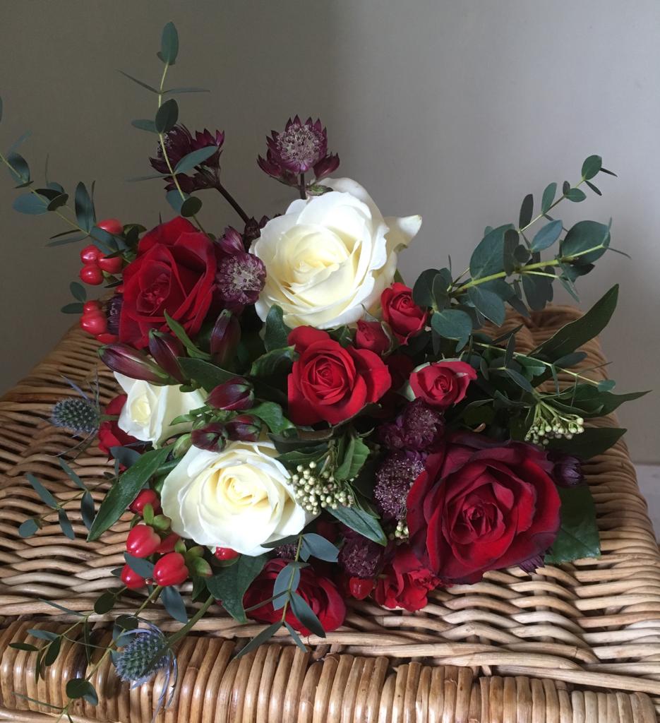 Red and white bridesmaids bouquet, with roses, greenery and seasonal berries